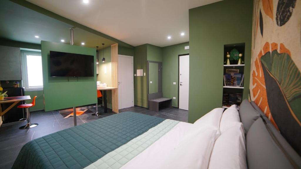 a bedroom with green walls with a bed and a flat screen tv at Didinas room in Potenza