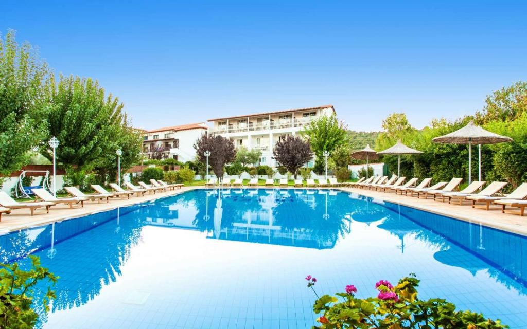 a swimming pool with lounge chairs and a hotel at Stellina Hotel in Skiathos