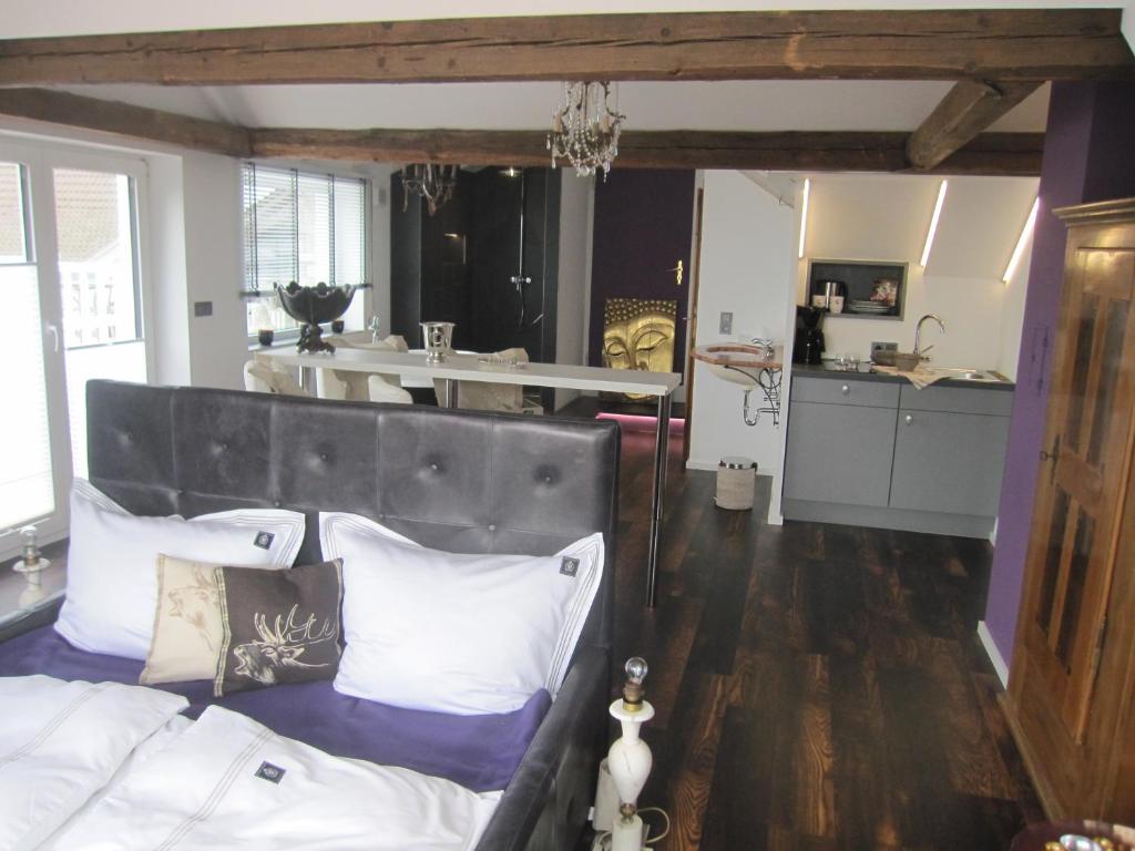 1 Schlafzimmer mit einem Bett mit Kissen und einer Küche in der Unterkunft Haus Grünewald Unsleben in Unsleben