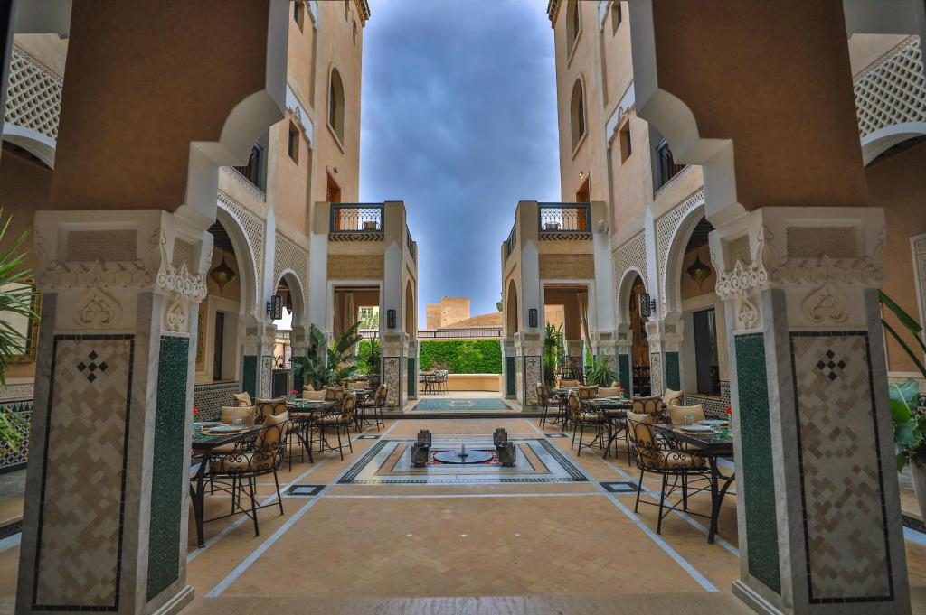 a courtyard with tables and chairs in a building at Dar Lys Luxury Riad & Spa in Fez