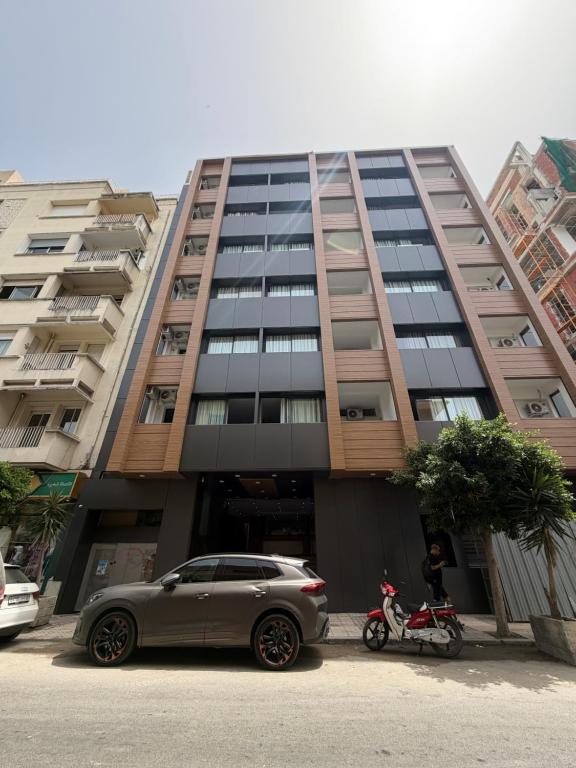 a car parked in front of a tall building at Nezha Hotel in Tangier