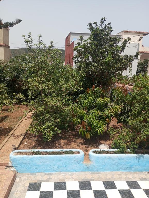 a pool in a garden with trees and a checkered floor at Amsa aqua villa in Tétouan