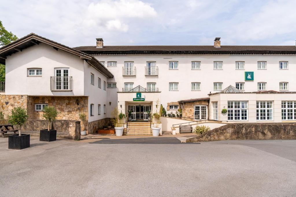 an exterior view of a large white building at Airport Inn Manchester in Wilmslow