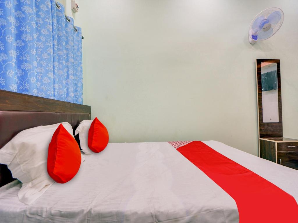 a bedroom with a bed with red pillows on it at Hotel O Kanha in Nagpur