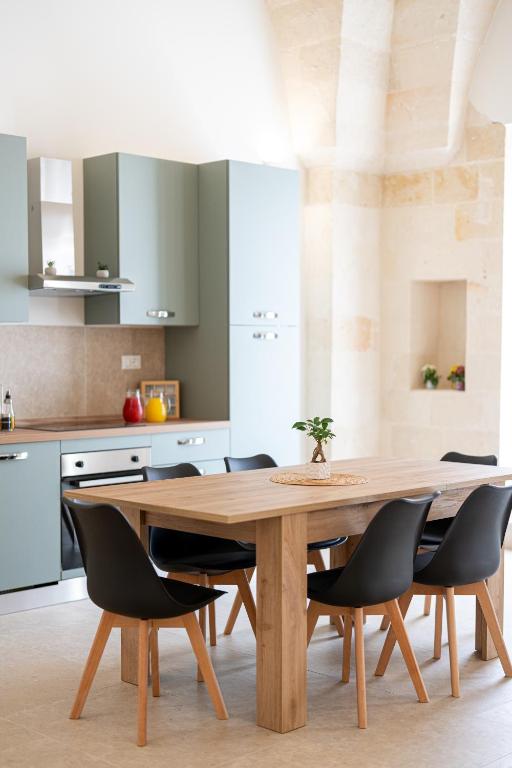 a kitchen with a wooden table and chairs at Le Volte in Lizzano