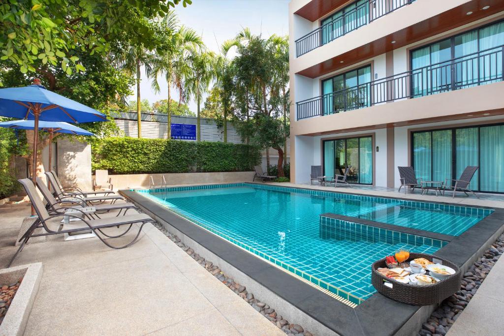 a swimming pool in front of a building at The BELL in Nai Yang Beach