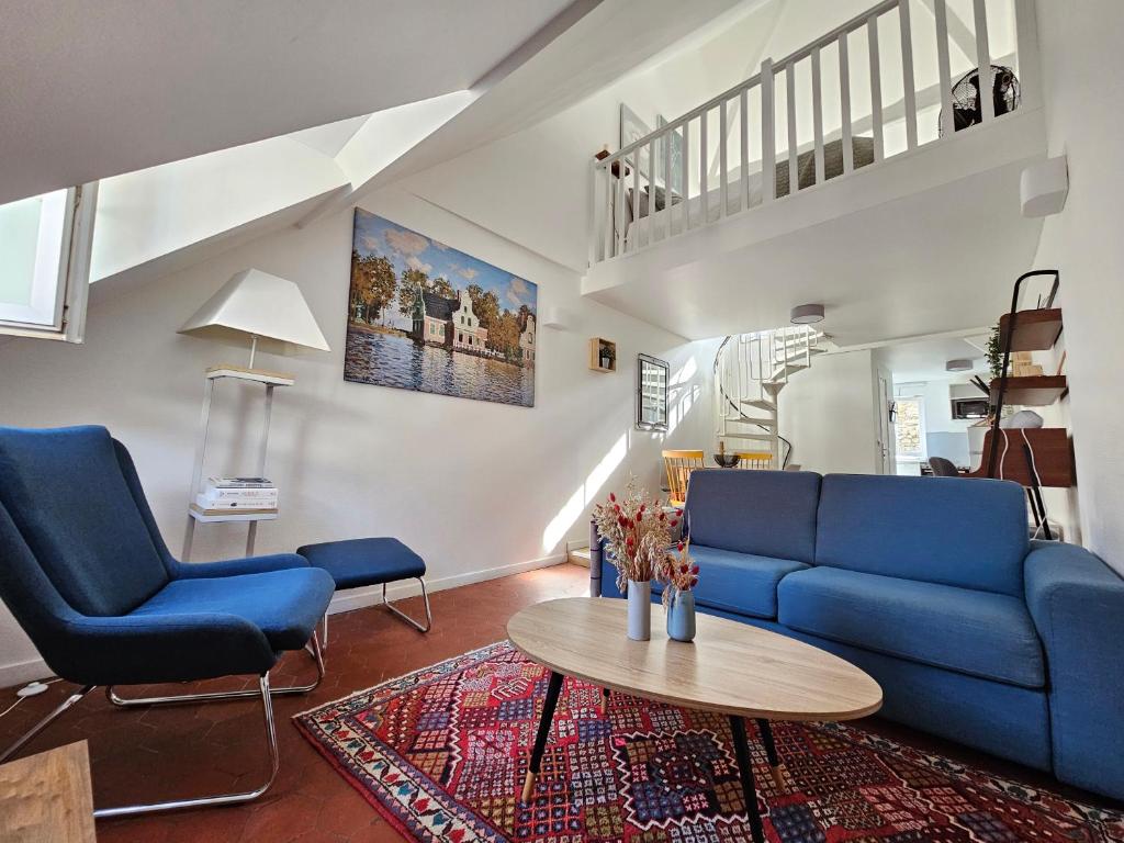 a living room with a blue couch and a table at Charmant Duplex au cœur de Vernon proche gare et Giverny in Vernon