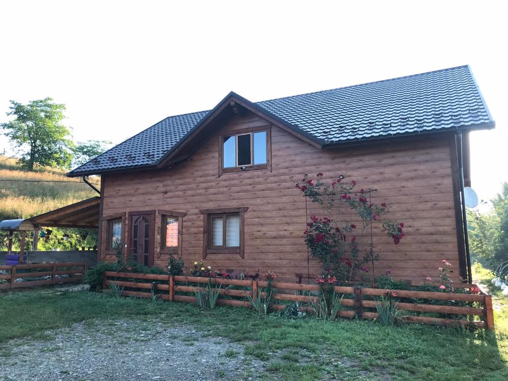 a wooden house with a fence in front of it at Карпатська перлина in Iltsi