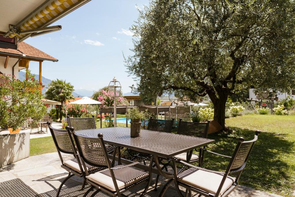 a table and chairs on a patio with a tree at Villa in Cermes