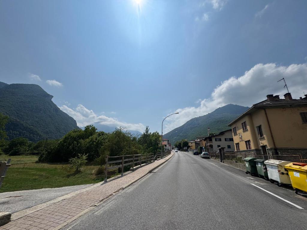 an empty road in a village with mountains in the background at RELAX APARTMENT in the Mountains in Valdieri