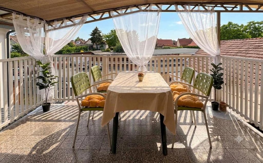 a table and chairs on a deck with a view at Lila Central Apartman in Balatonlelle