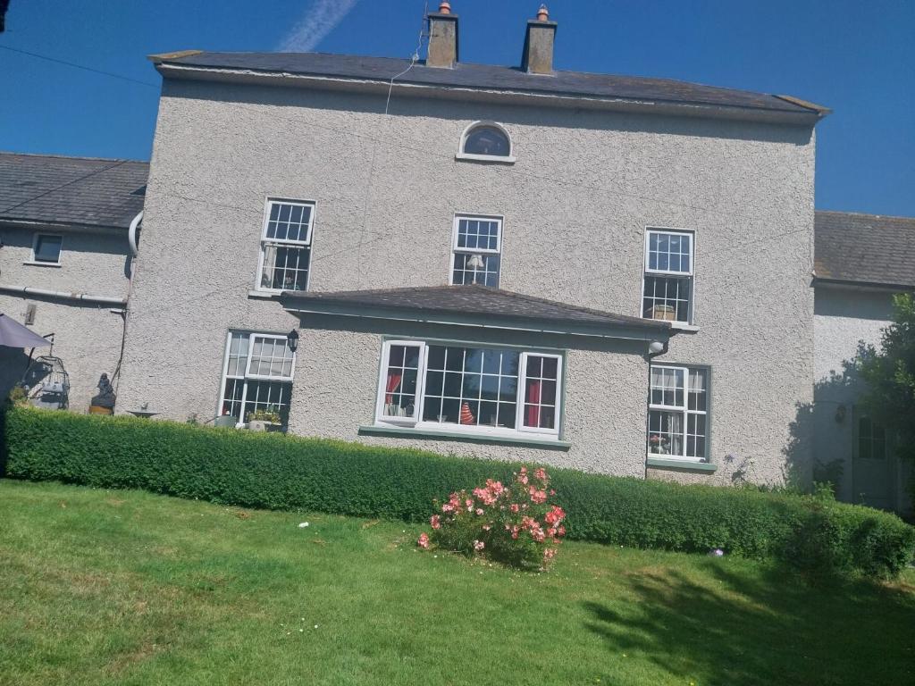 a large brick house with windows and a yard at Fortedward Farm House in Thurles