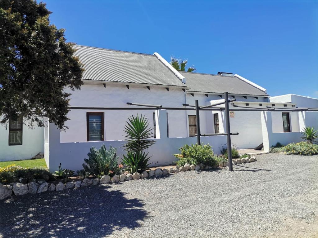 a white house with a gravel driveway at Harts Water in Jacobs Bay