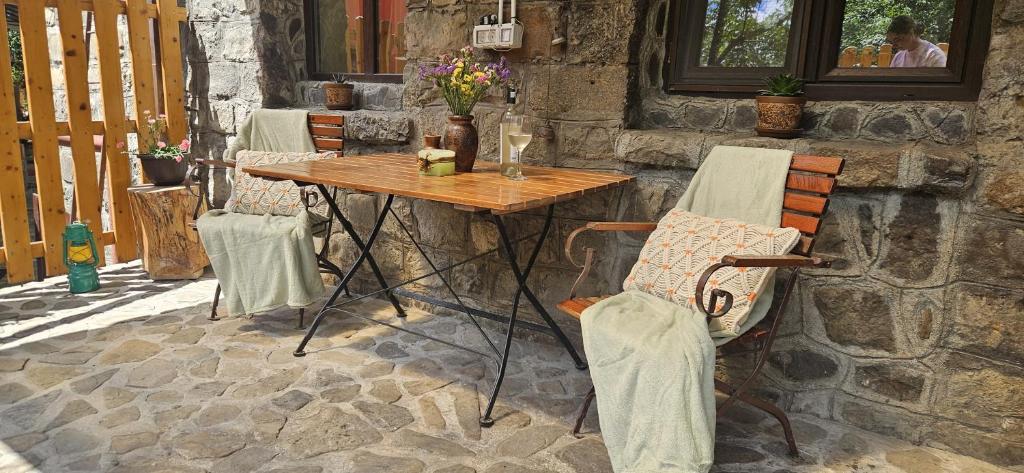 a wooden table and chairs on a patio at The Stone Garden Apartment - free parking, private yard in Sinaia
