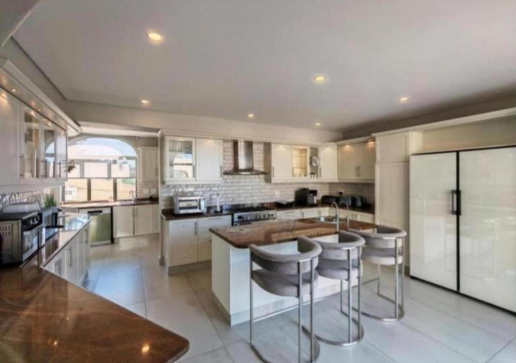 a kitchen with a island with bar stools at Apartment 24 in Durban