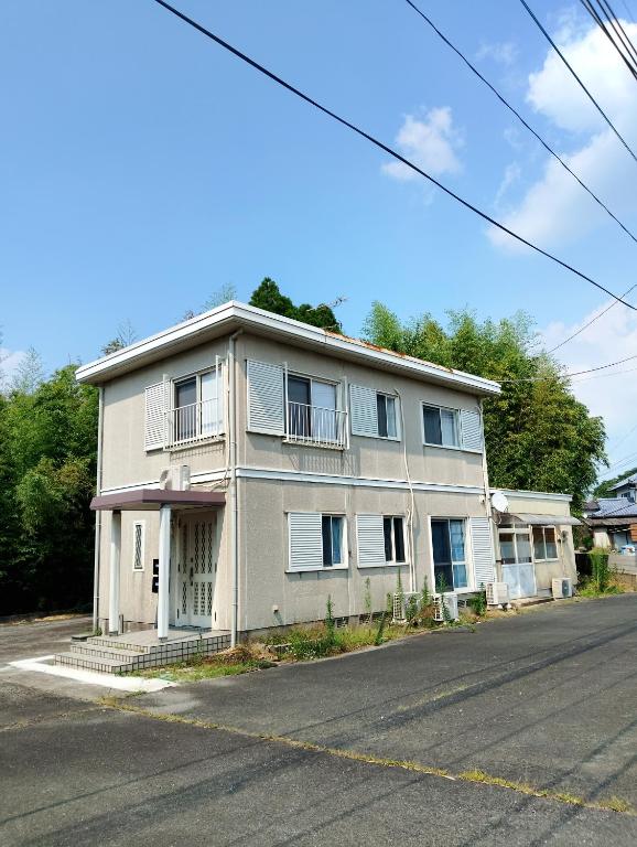 a white house on the side of a street at ゲストハウス紗乃葉 - Suzunoha in Bōchū