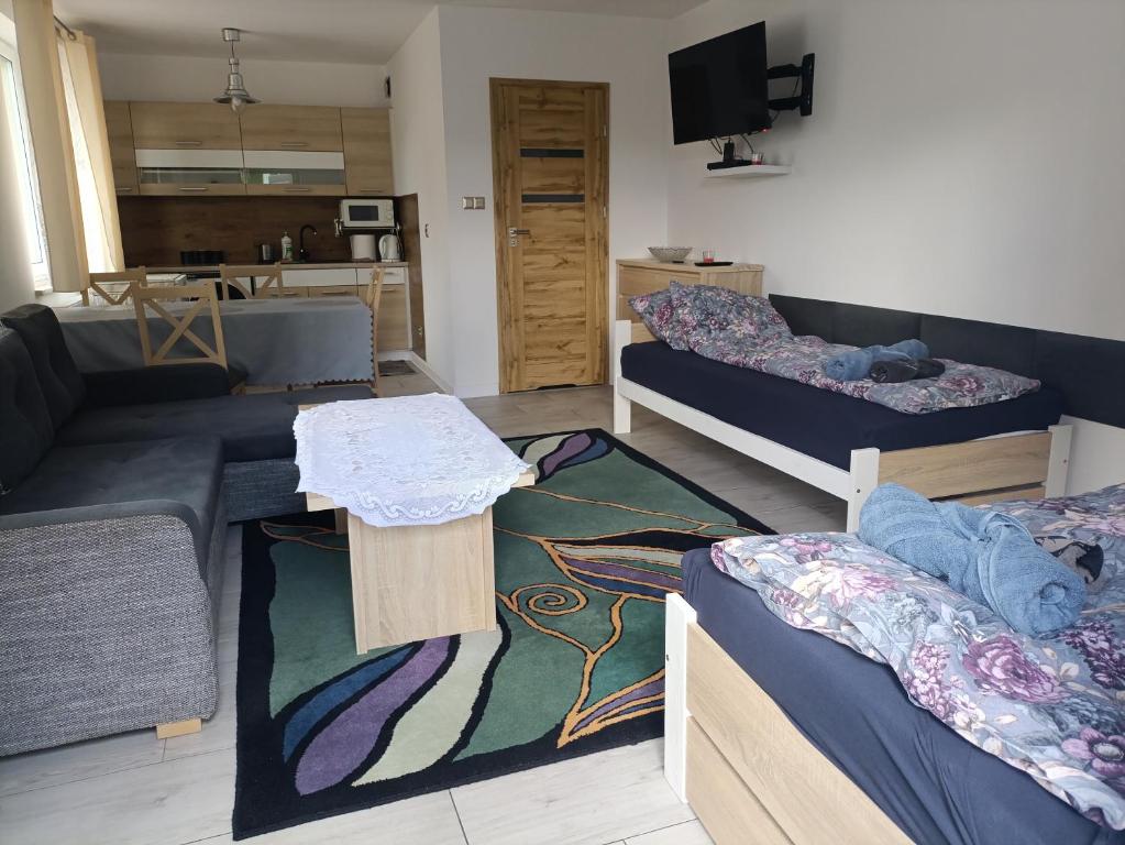 a living room with two beds and a couch at Apartament Przylesie 2 in Stężyca