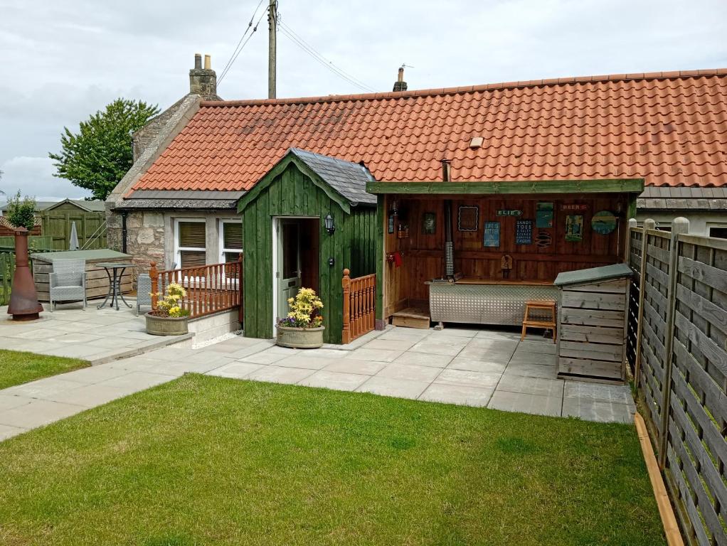 a green shed with a bench in a yard at West Stable Cottage in Cameron