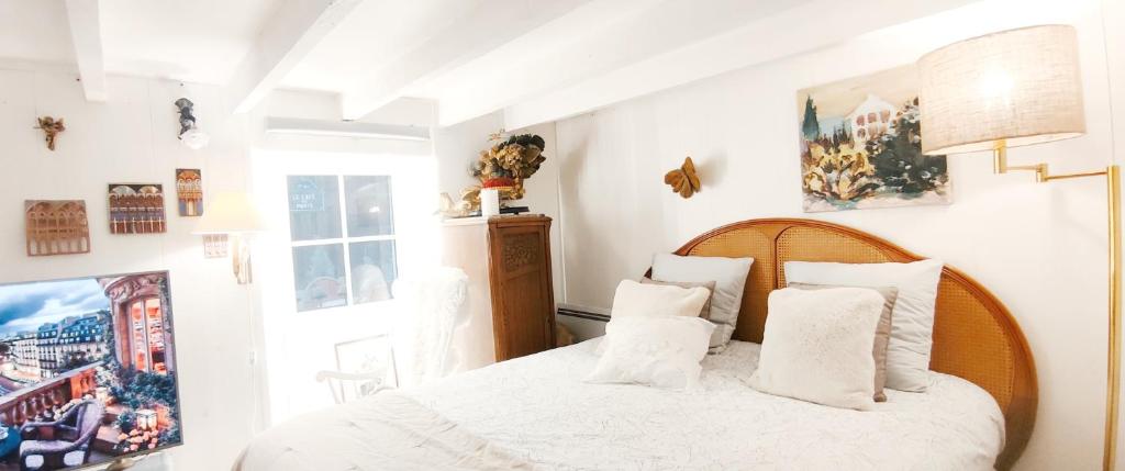 a bedroom with a bed with white sheets and pillows at PARIS AUTHENTIC HOUSE open space studio Métro 14 Hôpital Bicêtre, RER B Gentilly in Gentilly