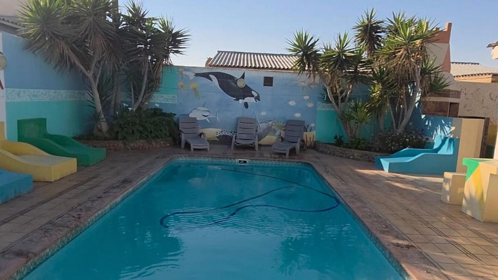 a swimming pool with a dolphin painted on the side of a house at Mizpah Self Catering Accommodation in Walvis Bay