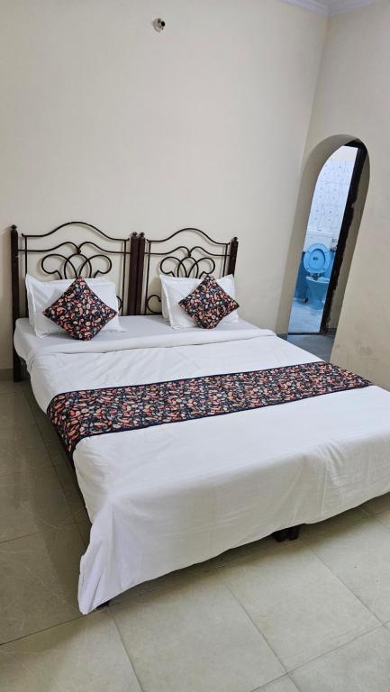 a large bed with two pillows on top of it at Value Stays By Amisha Palace in Jaipur