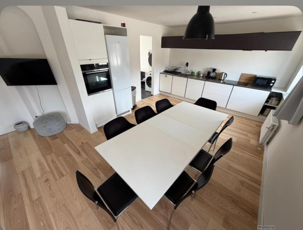 a dining room with a white table and chairs at 24 h chek in big house in Copenhagen
