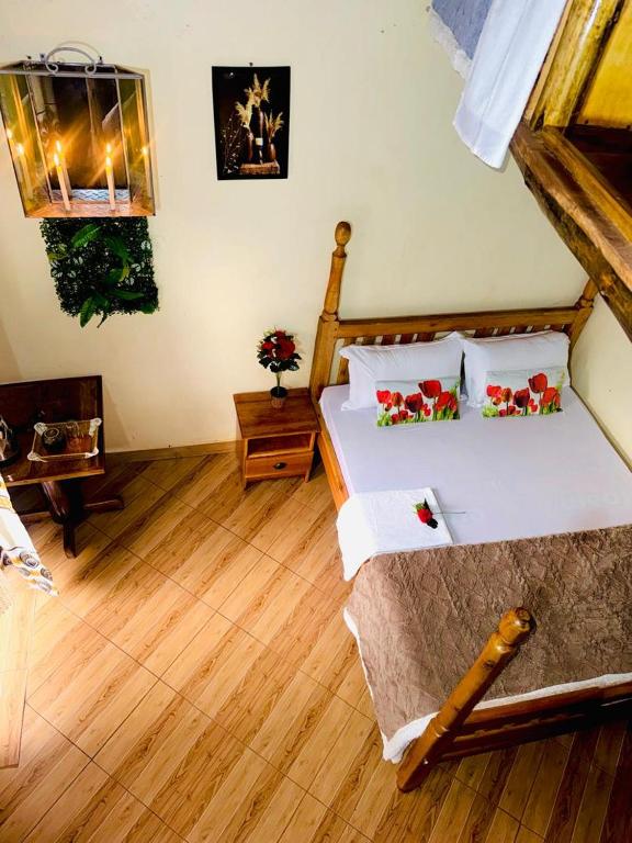 a bedroom with a bed and a wooden floor at Eagle Nest in Namulanda