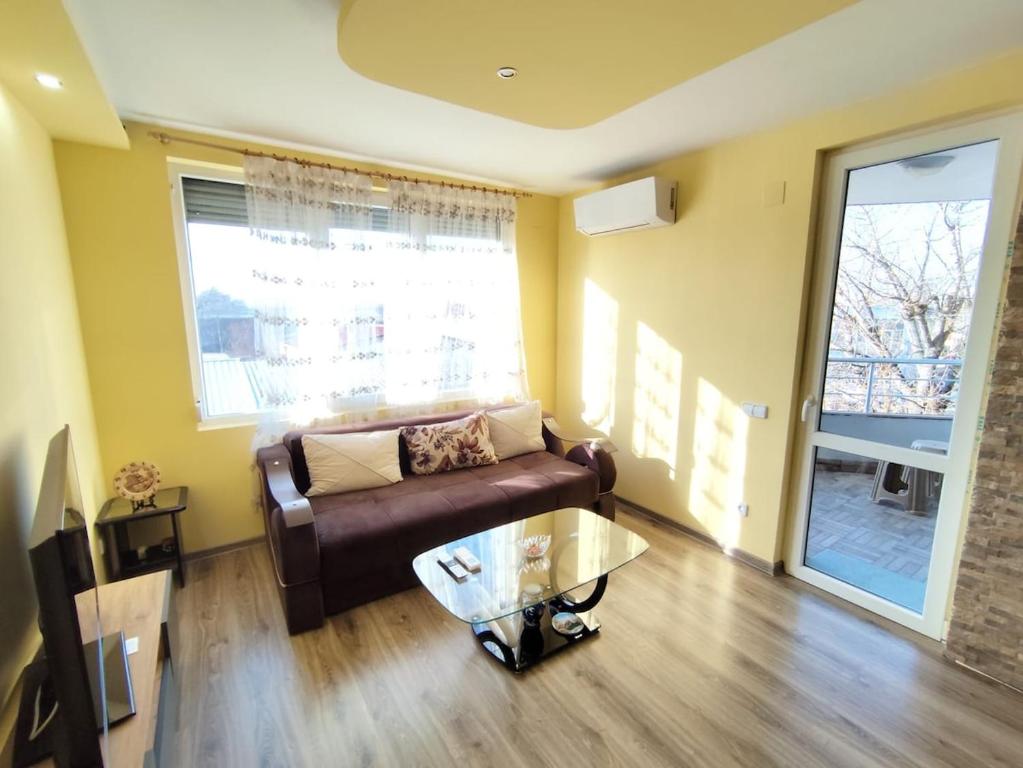 a living room with a couch and a glass table at Charming Apartment with balcony in Vidin