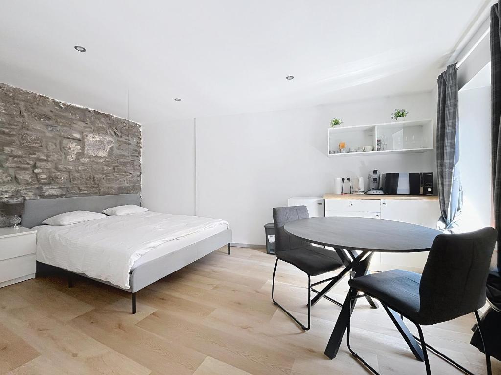 a bedroom with a bed and a table and chairs at Third Corner in Liège