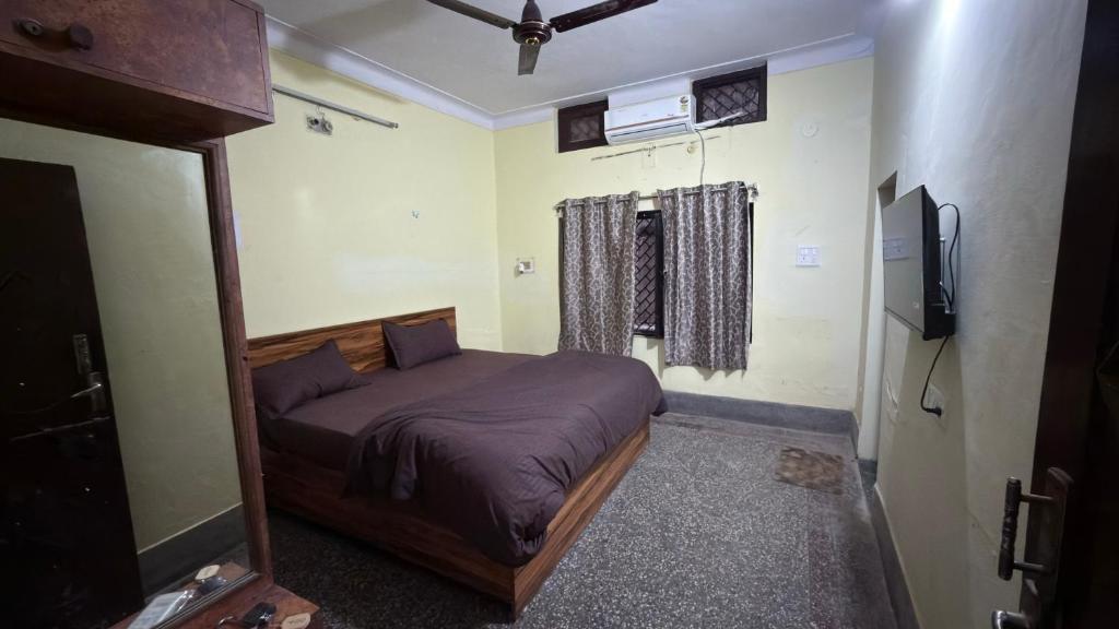 a bedroom with a bed and a flat screen tv at Hotel Golden Pearl in Rewa