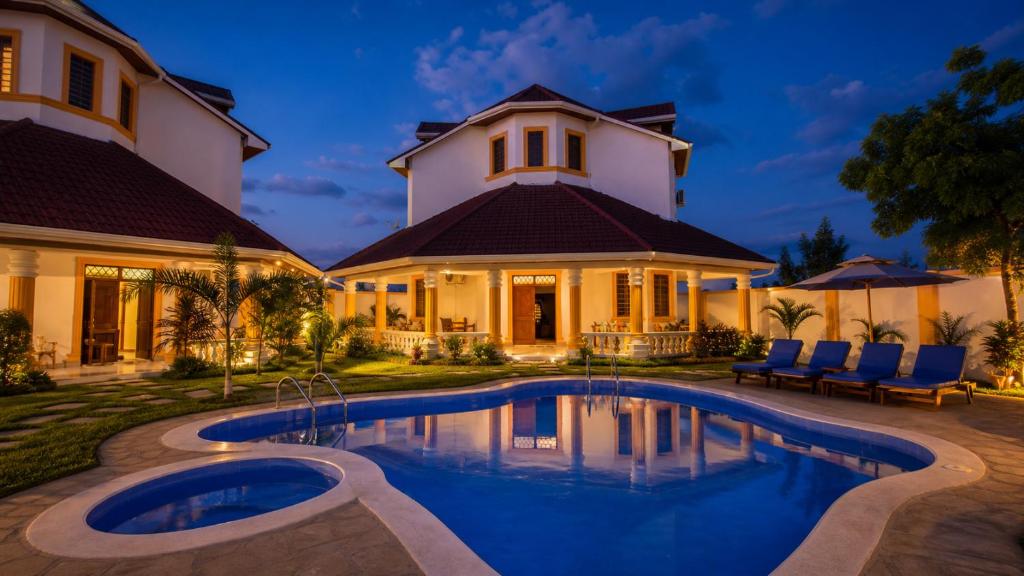 a house with a swimming pool in front of a house at Greenfield Villa M- Diani Beach in Ukunda