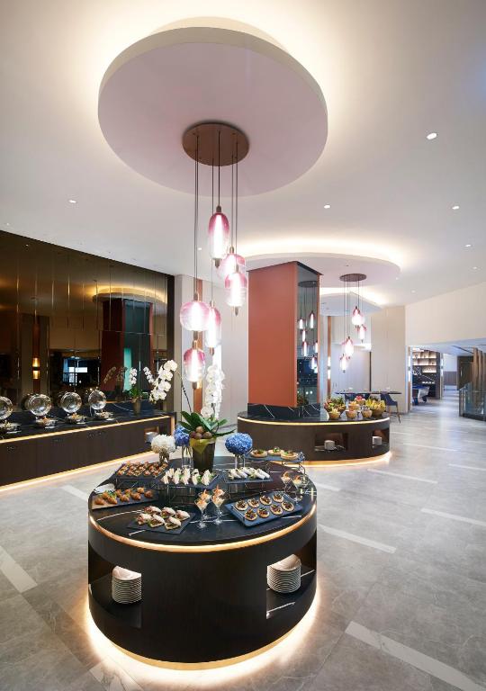 A close view of a round buffet island with decorated dishes beneath pendant lights.