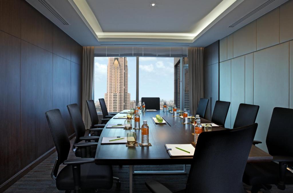 A private boardroom with a long meeting table and a city-facing window.