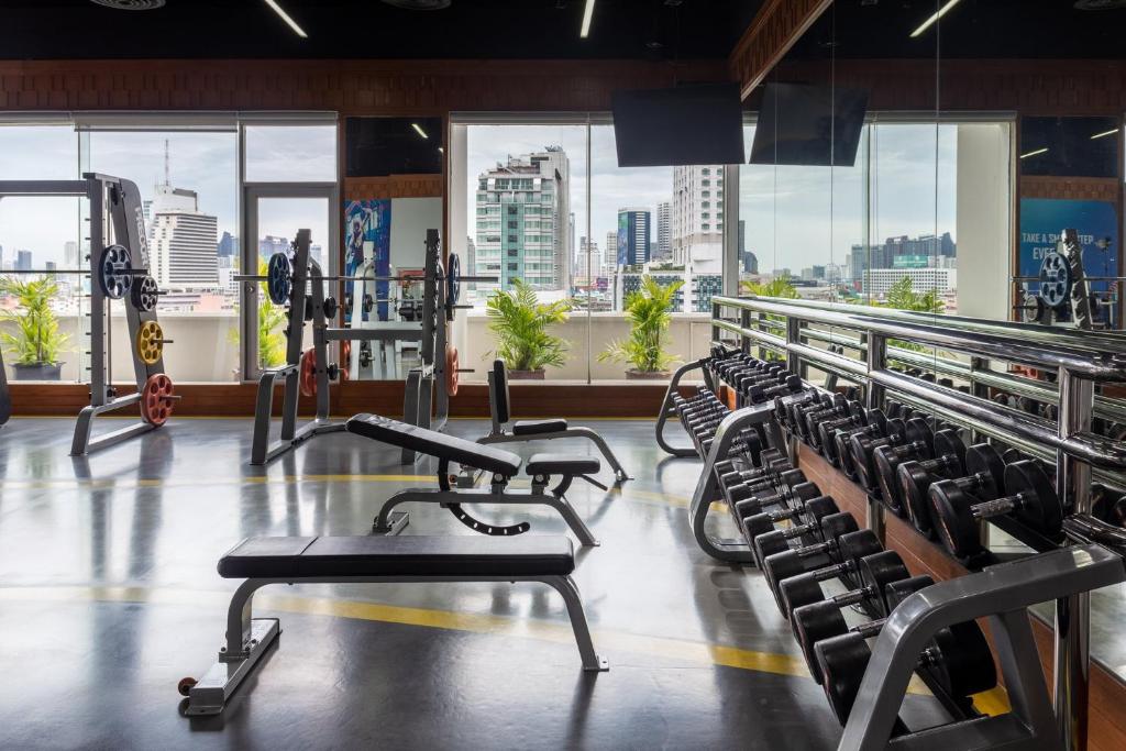 A weight-training area with benches, racks and a city view.