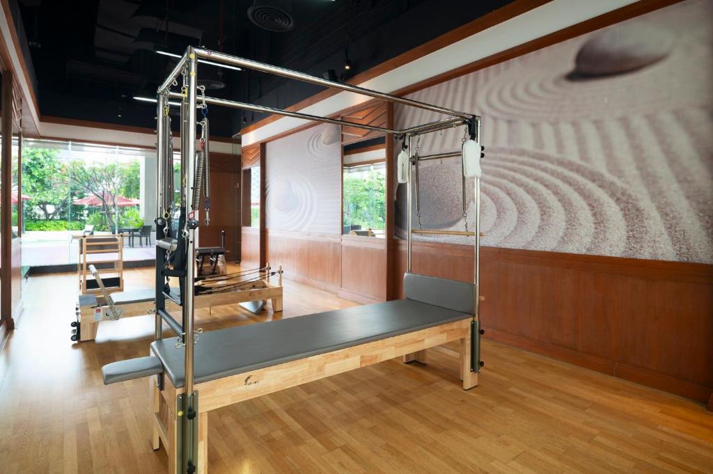 A wood-floored studio containing a large Pilates reformer and other training equipment.