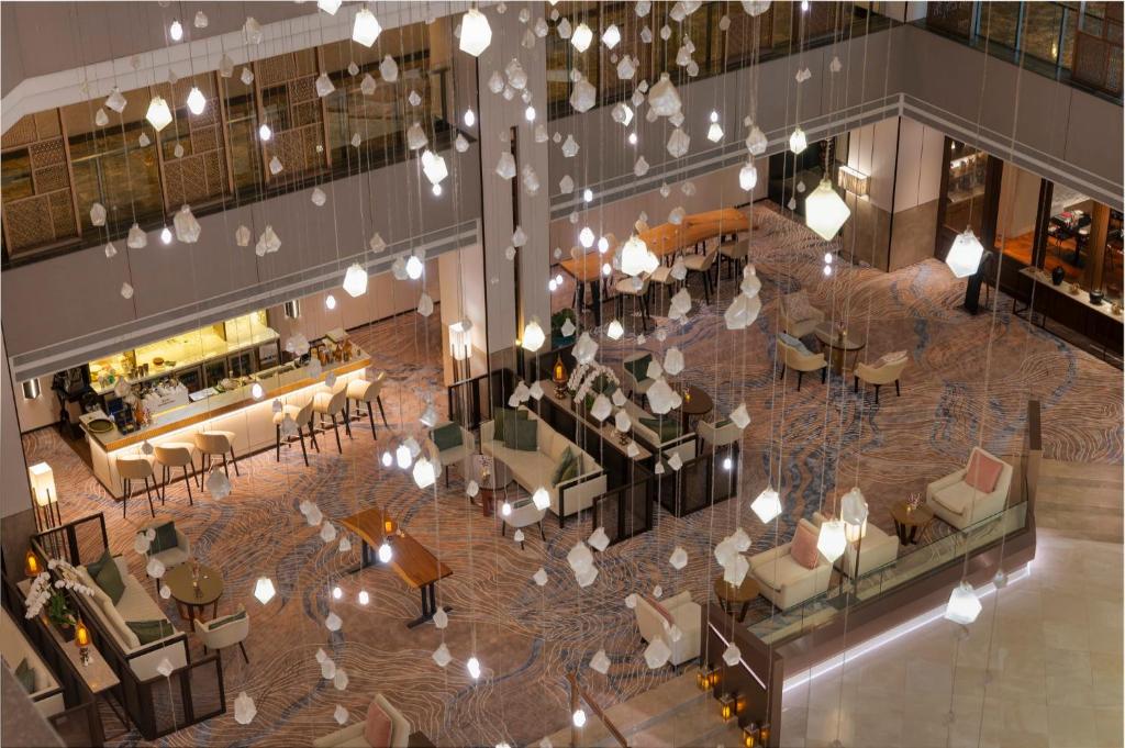 An elevated view across the hotel lobby, lounge seating, and bar.