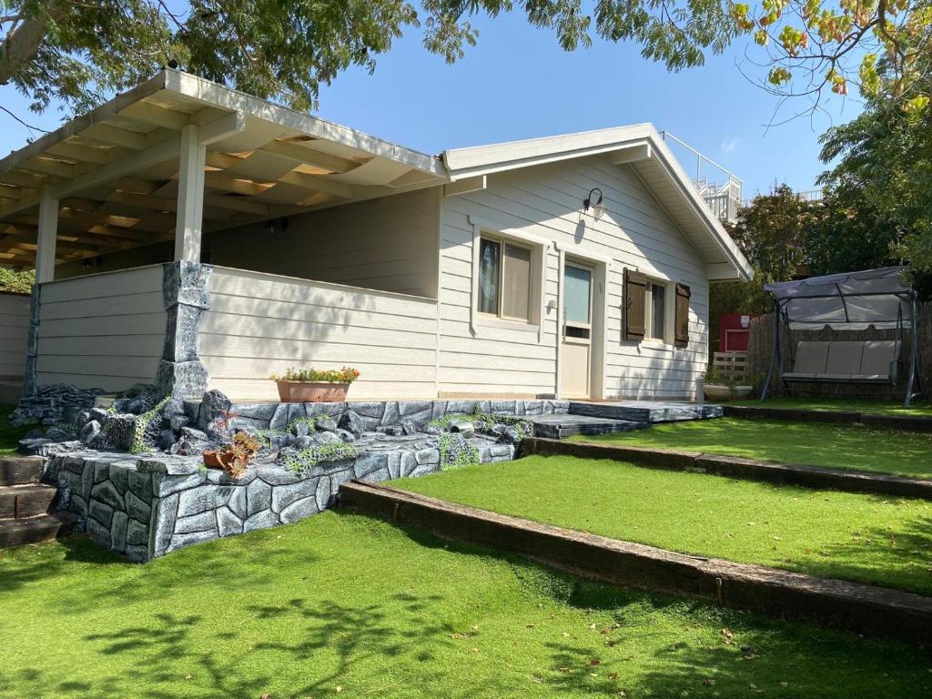 a house with a stone retaining wall in the yard at Lakeside Terrace in Neot Golan