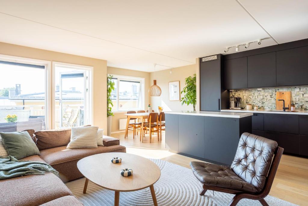 a living room with a couch and a table at Modern 3 bedroom apartment - 4 minute walk from metro - top floor baclony view in Oslo