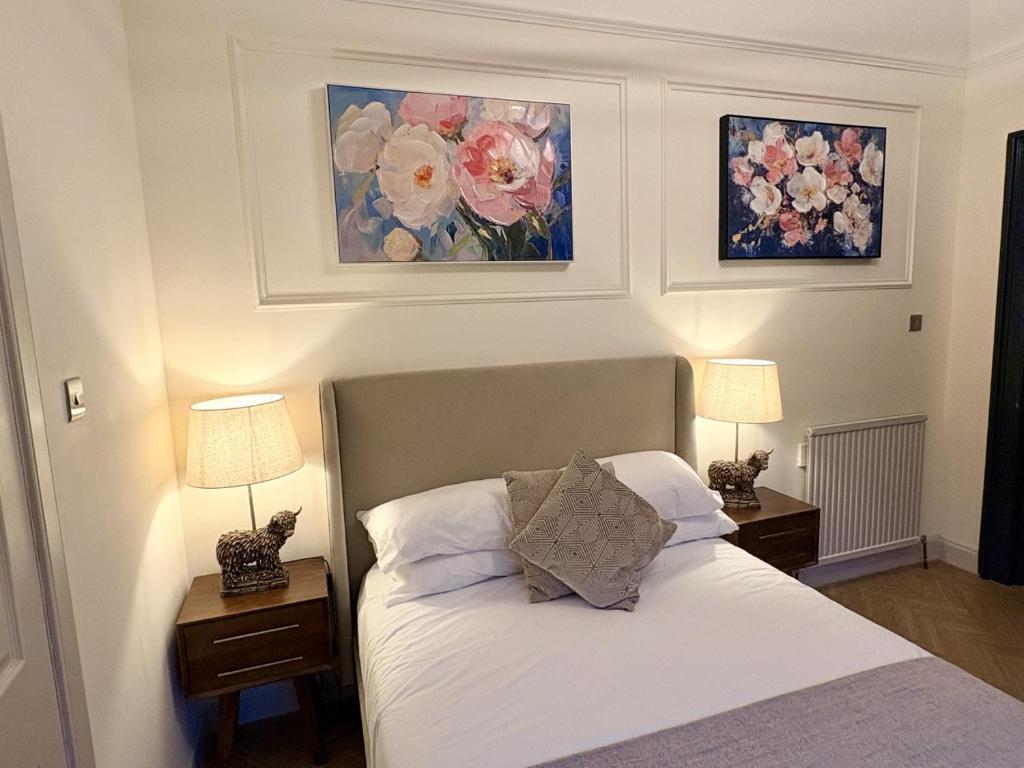 a bedroom with a bed with two nightstands and two lamps at 'Mac' in ApartNest Auchterarder in Auchterarder