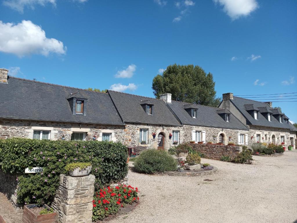 a row of houses with flowers in a yard at Les Gites de Kerroyal in Garlan