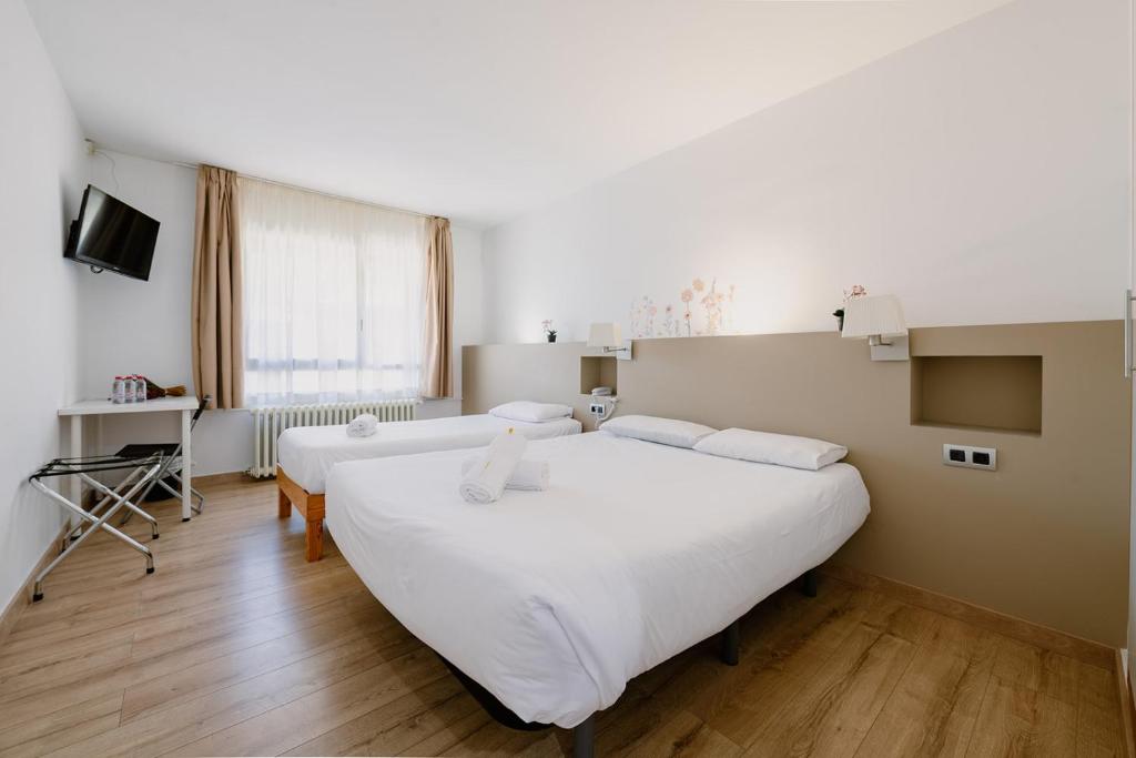ein Schlafzimmer mit zwei Betten und einem Fernseher in der Unterkunft Hotel Terranova in Pas de la Casa