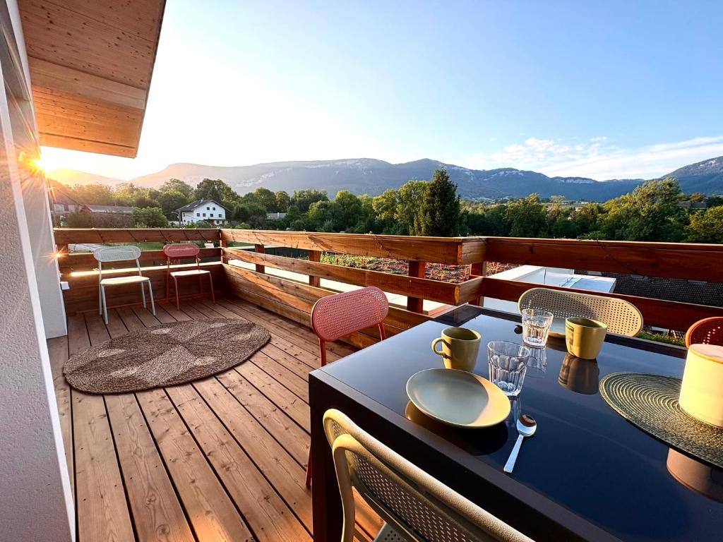 a balcony with a table and chairs on a deck at La Villa d'Aix - Entre lacs et montagne - Jacuzzi in Saint-Ours