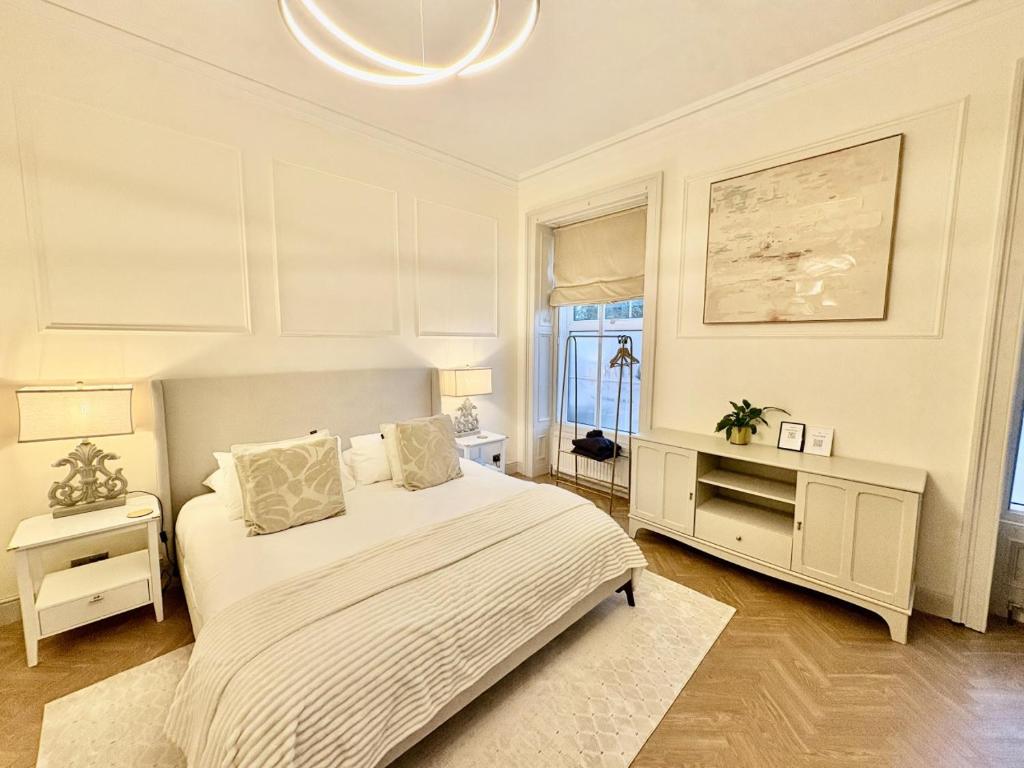 a white bedroom with a bed and a window at 'Blair' in ApartNest Auchterarder in Auchterarder