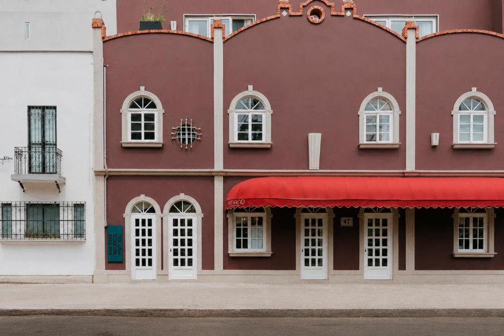 a red and white building with a red awning at Maximo Mexico Roma in Mexico City