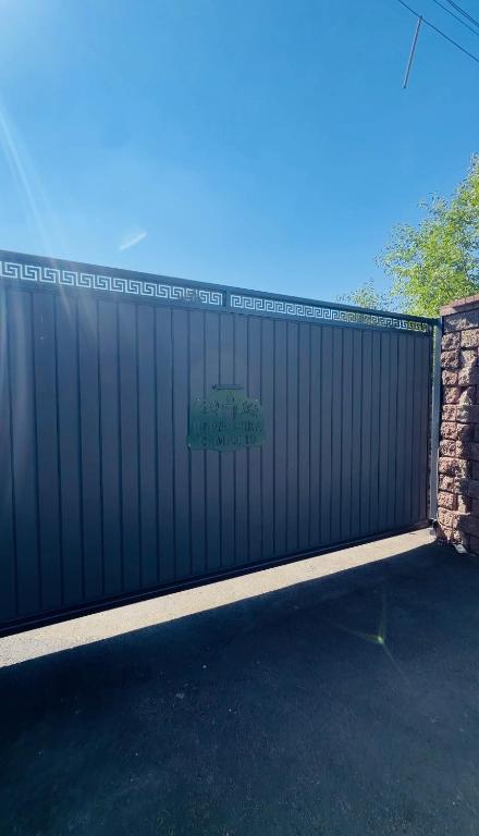 a black fence with a sign on top of it at Пар&Речка in Almaty