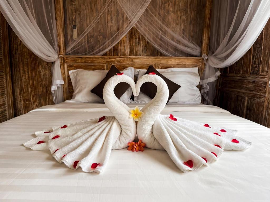 two swansuitsrendered to look like they are kissing on a bed at Villa Wakem Yehpoh in Yehpoh