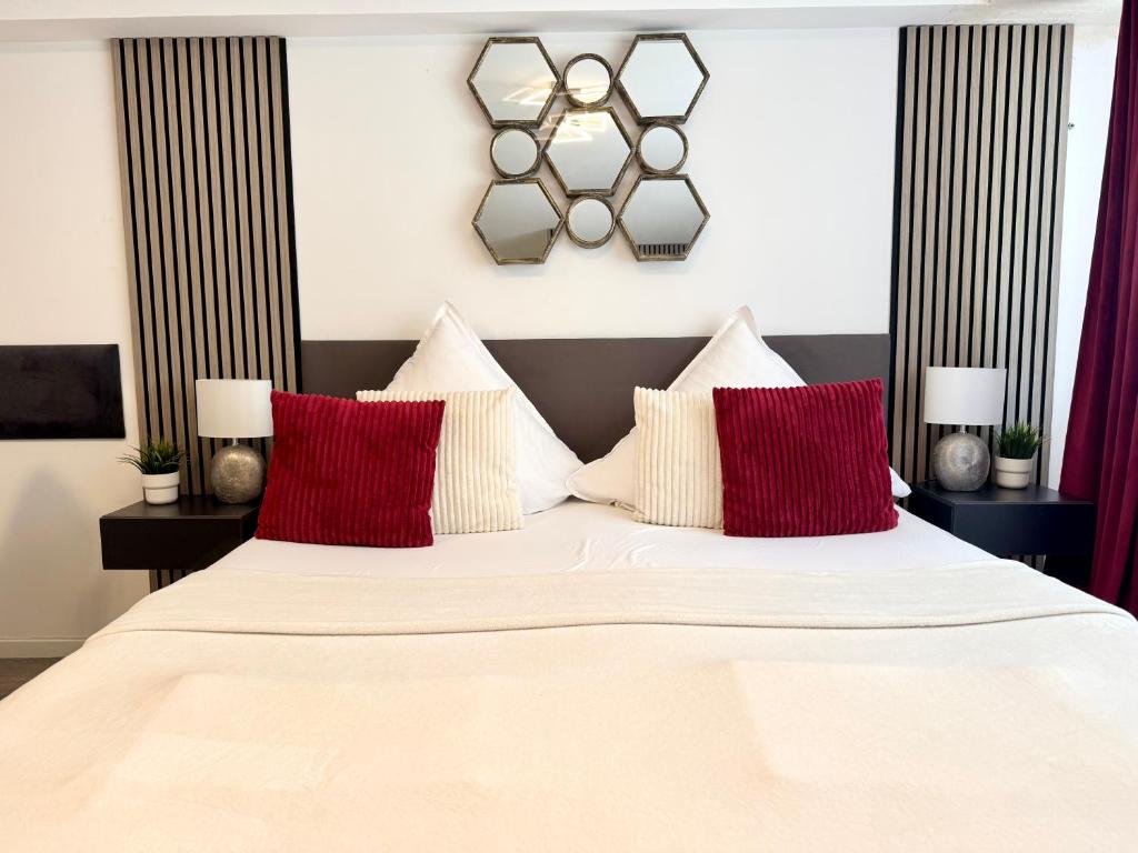 a bedroom with a large white bed with red pillows at Prime Host Dream Deluxe in Karlsruhe