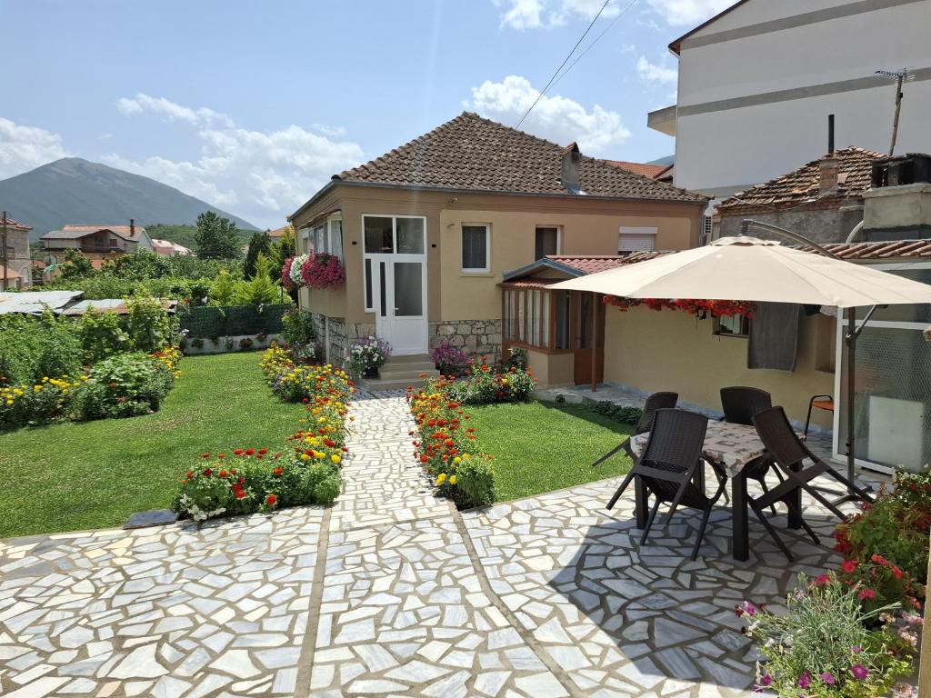 a patio with an umbrella and chairs and a house at GRANDPA's HOME in Pusteci