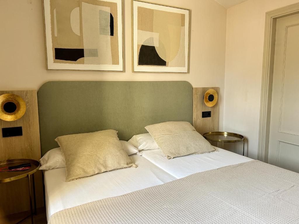 a bedroom with a white bed with two pillows at Hostal Rural Sositana in Castejón de Sos