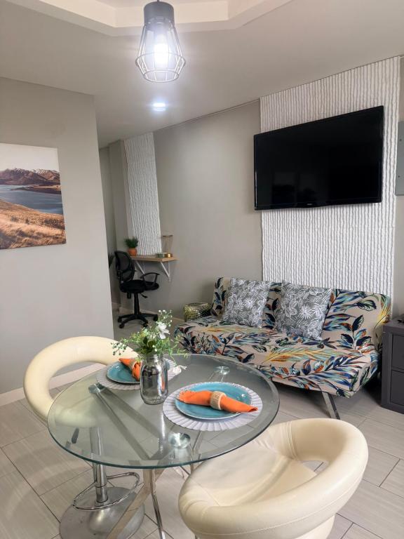 a living room with a glass table and a couch at A Hidden Gem 2BR apartment in Couva